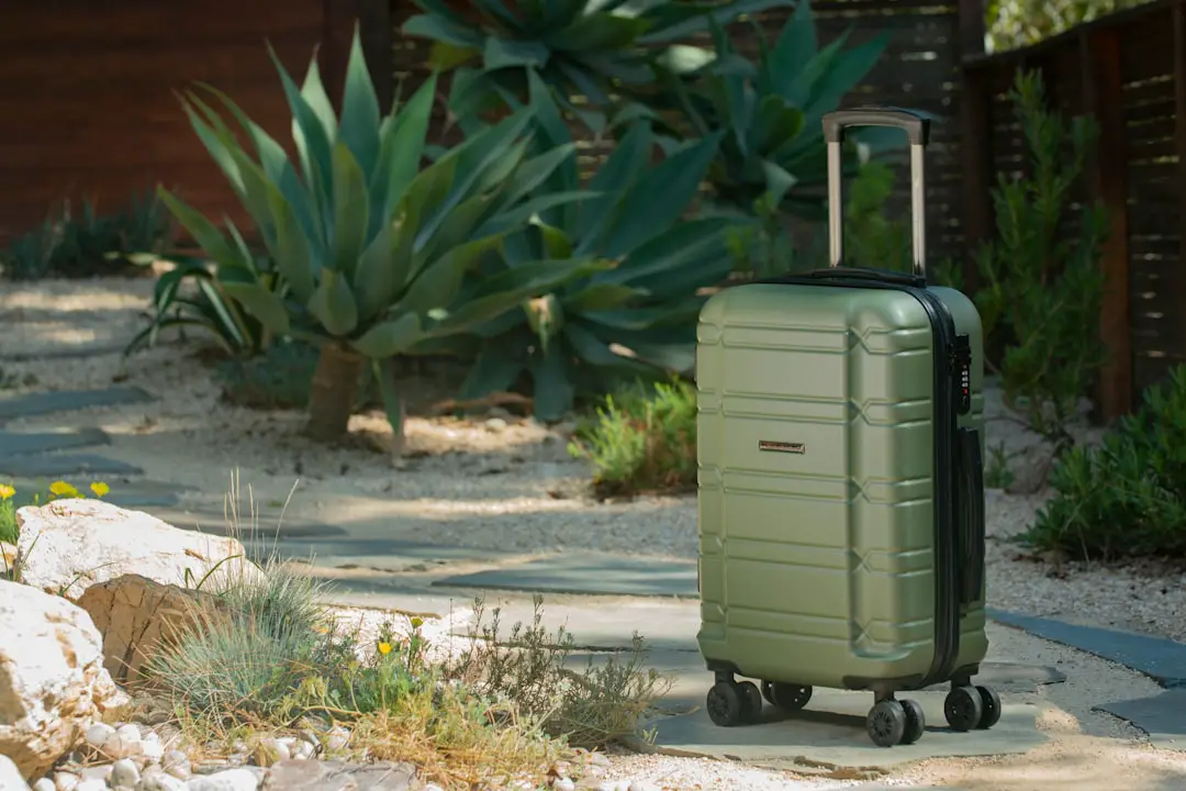 a green suitcase sitting on top of a sidewalk
