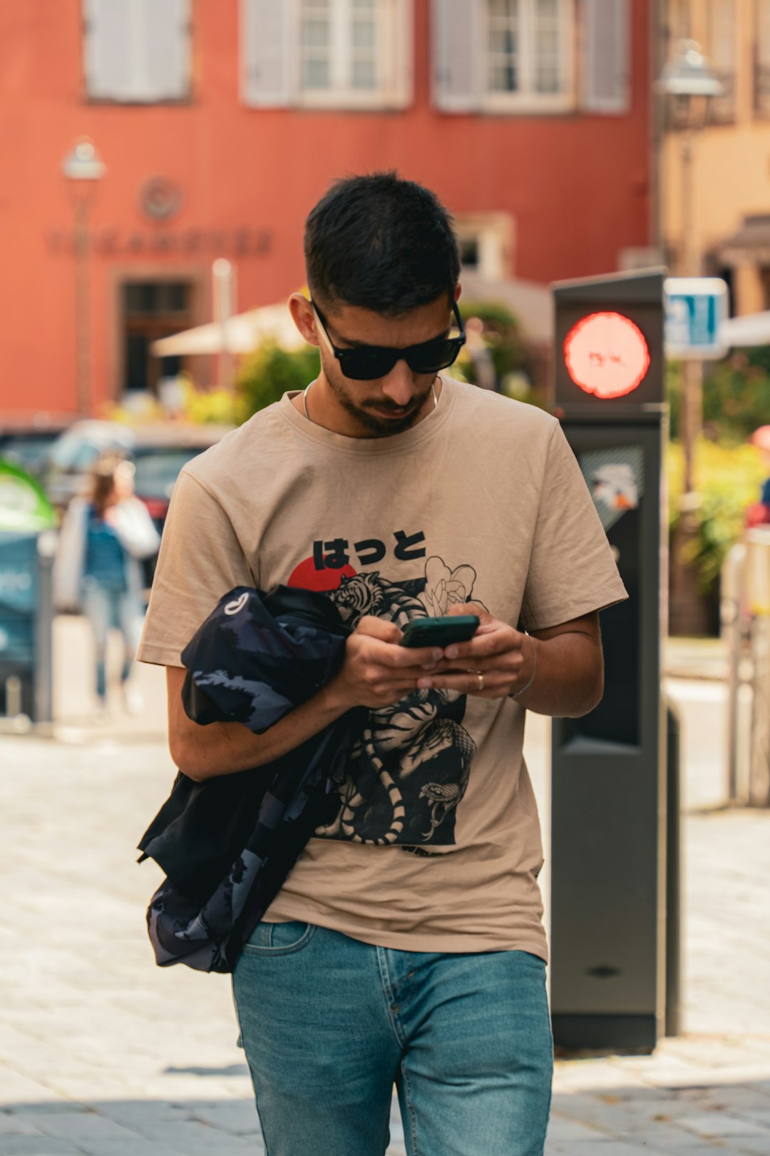 A man walking down the street looking at his cell phone