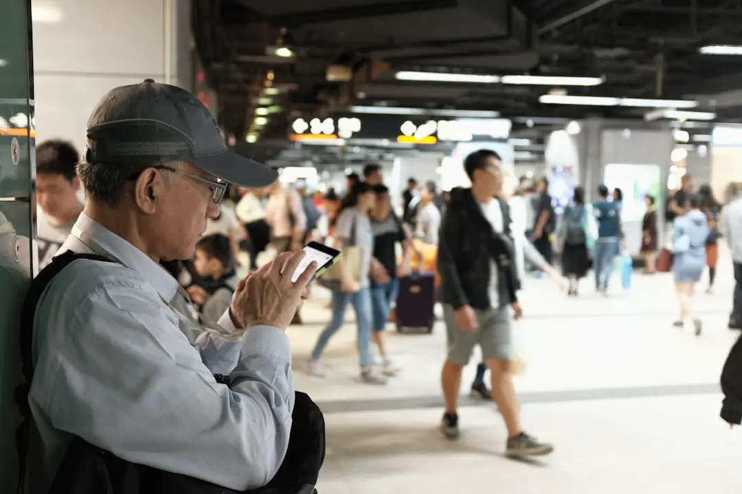 man in white dress shirt and black cap holding smartphone